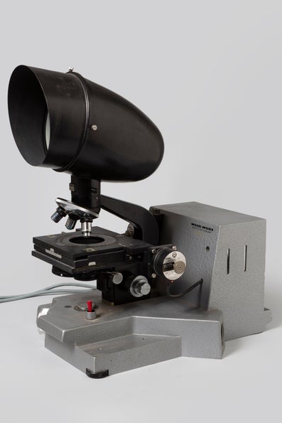 A black coloured microscope against a white background