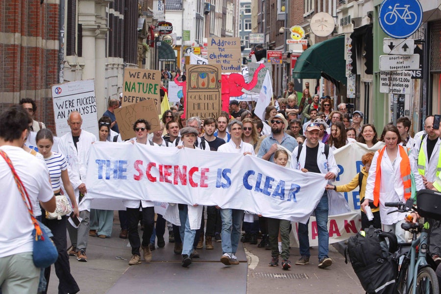 klimaatprotest met wetenschappers die een spandoek met 'the science is clear' dragen