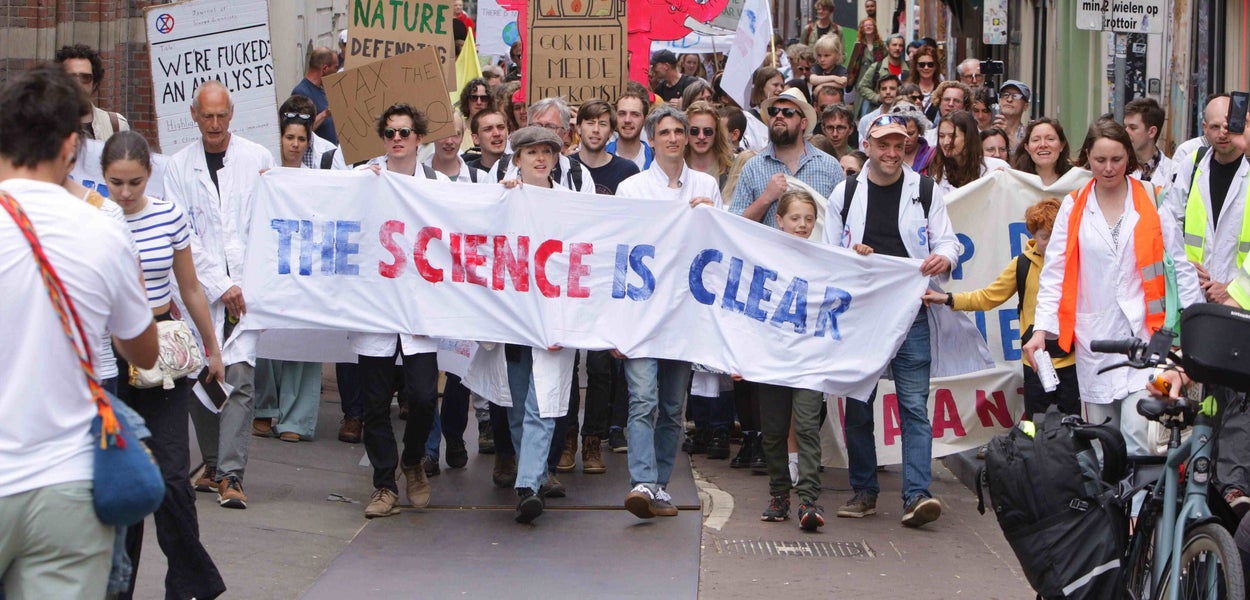 klimaatprotest met wetenschappers die een spandoek met 'the science is clear' dragen
