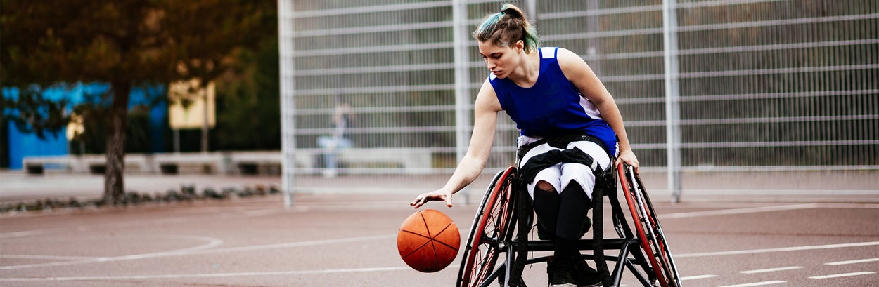 Vrouw speelt basketbal in een rolstoel