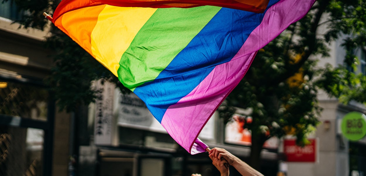 Een regenboogvlag wordt door een persoon gevlogen