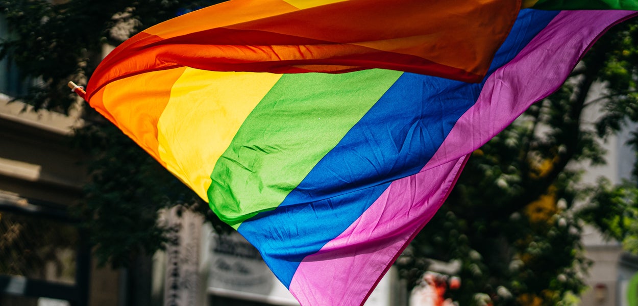 A rainbow flag is being waved by a person
