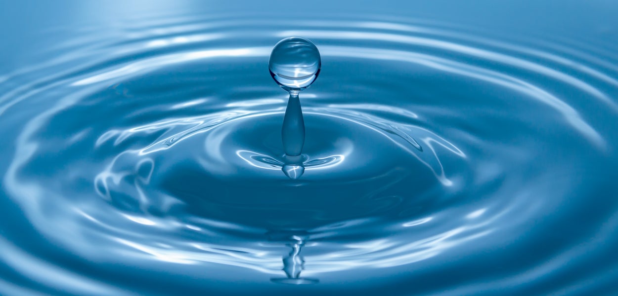 Water drop resulting in ripple in water, symbolic of impact of education and research