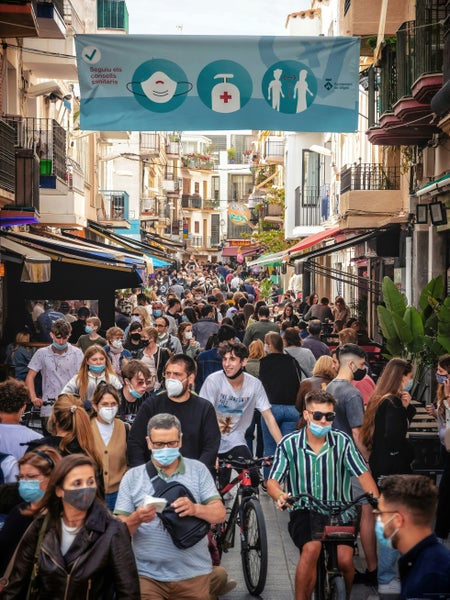 Drukke straat met mensen met mondkapjes