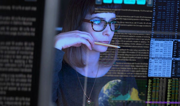 A woman studying data on a computer