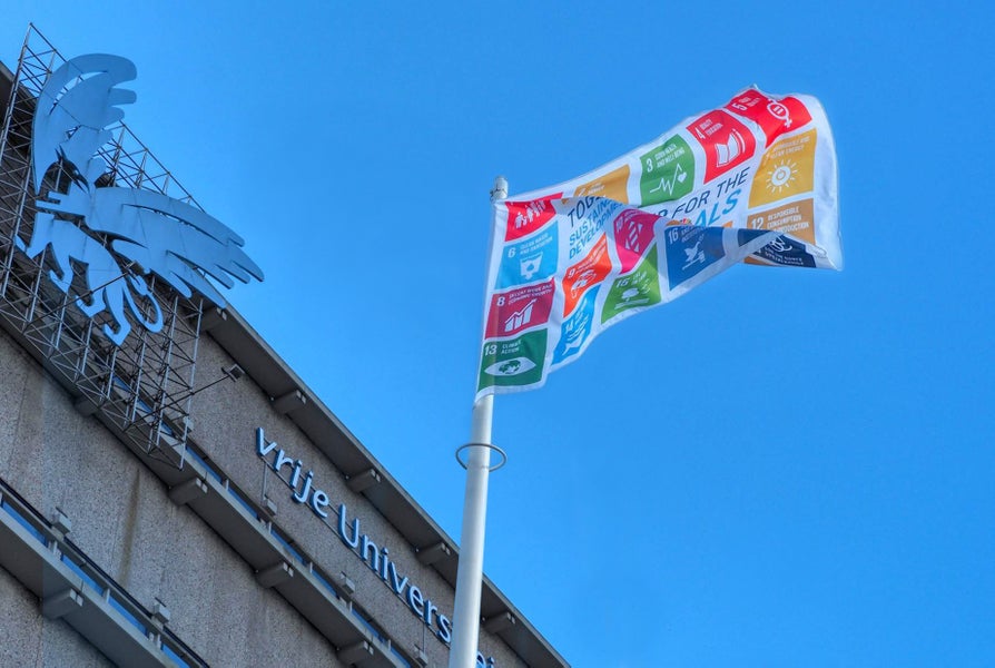 Een vlag met de Sustainable Development Goals voor het Hoofdgebouw van de VU.