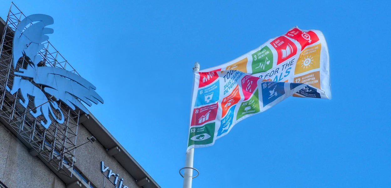Een vlag met de Sustainable Development Goals voor het Hoofdgebouw van de VU.