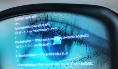 Someone's eye looking at computer data through glasses