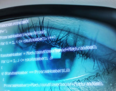 Someone's eye looking at computer data through glasses
