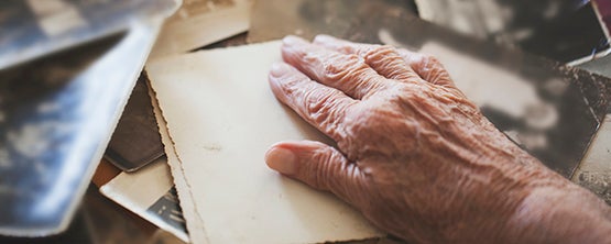 Hand of elderly with black and white photos