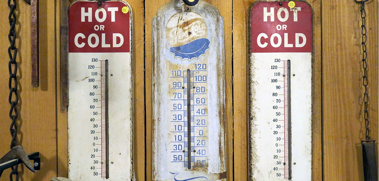 Foto met 3 thermometers aan een houten wand